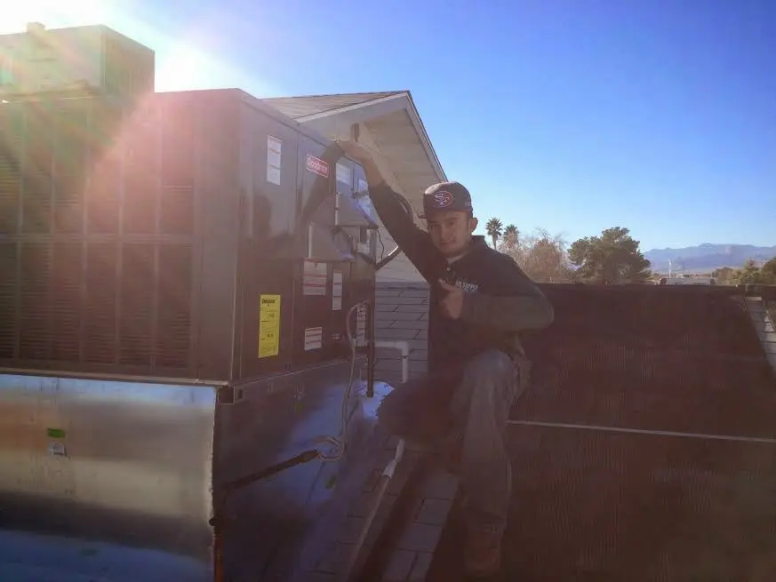 HVAC technician performing Air Duct Cleaning on a rooftop unit in Santa Barbara